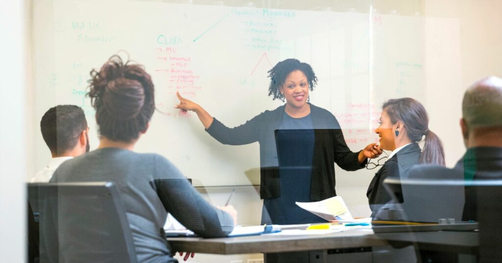 A woman presenting to colleagues, discussing and educating stakeholders during a professional presentation.