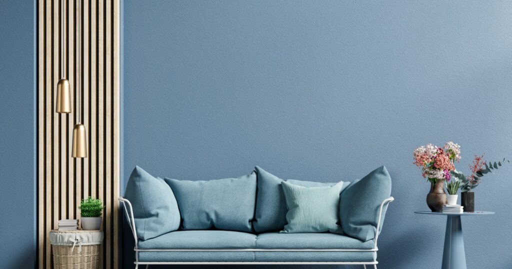 Modern blue sofa against wooden wall.