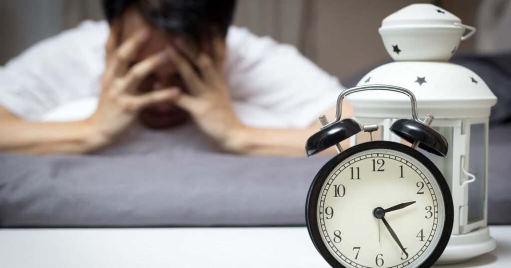 Resting man with alarm clock nearby.