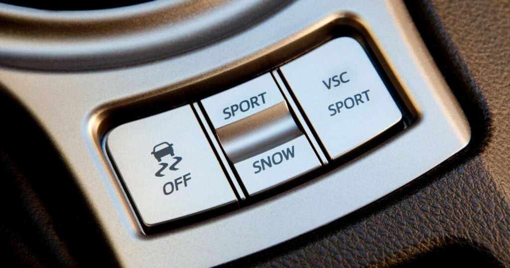 Close-up of car control panel button with traction control feature.