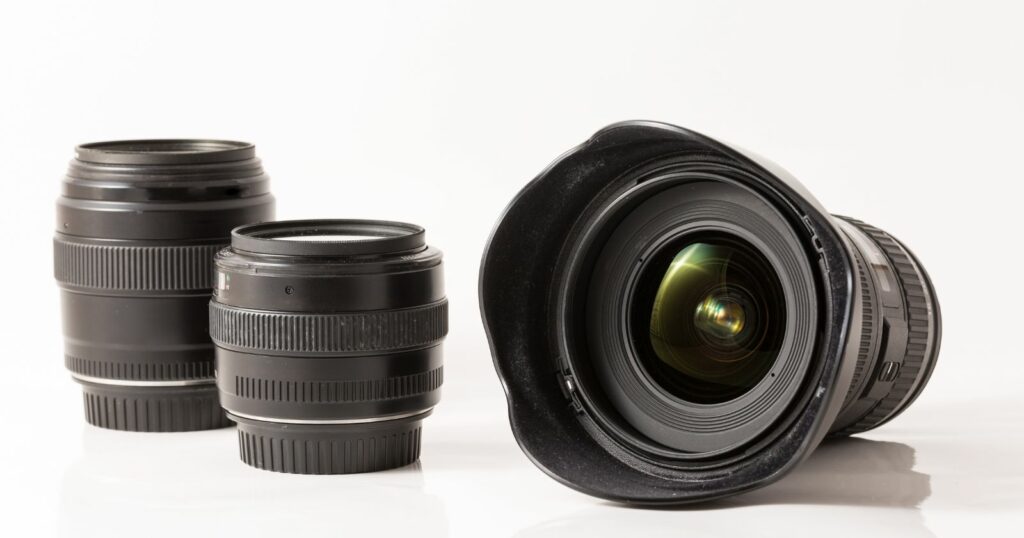 A close-up of a cinematography camera lens and its lens cap placed side by side.