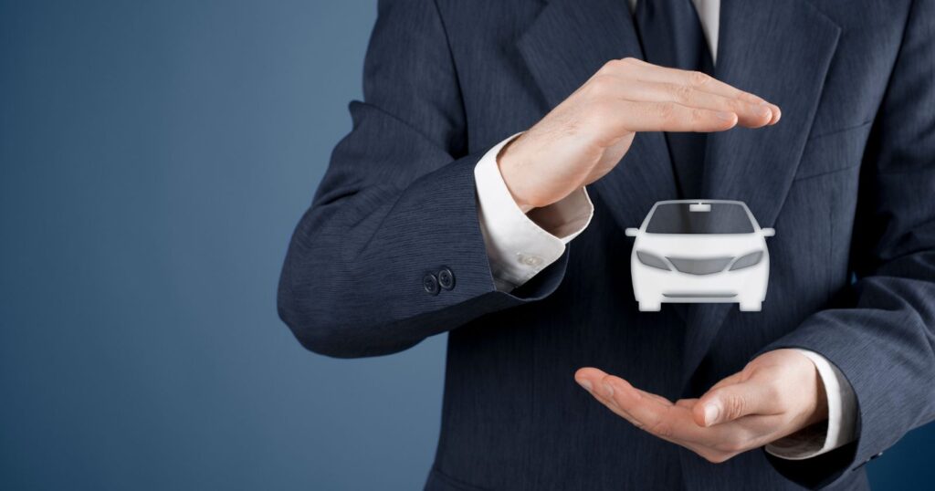 A man in a suit holding a small car, representing the importance of car insurance.