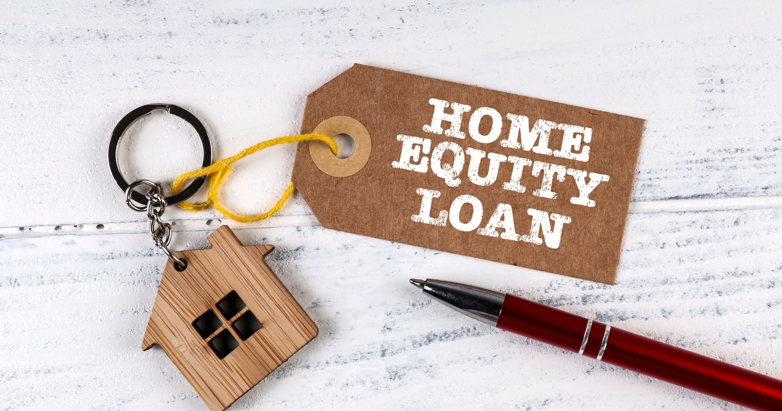 A graphic displaying the words 'Home Equity Loan' in bold letters against a backdrop of a house and a dollar sign."