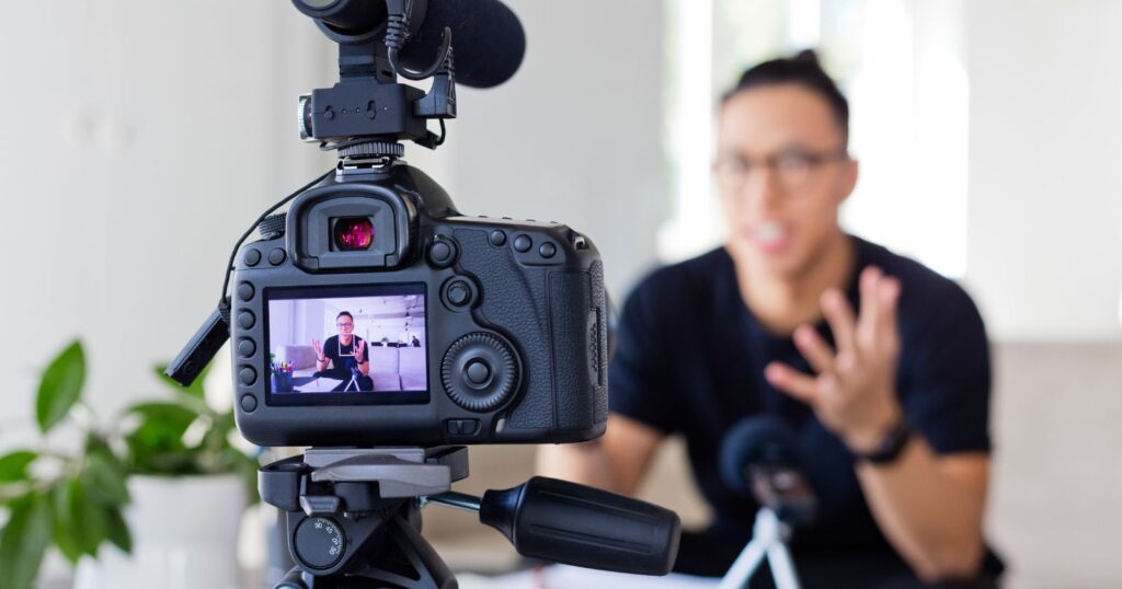 A person multitasking: holding a camera and talking on the phone. Capturing moments while discussing 'Leveraging Blogging for SEO'.