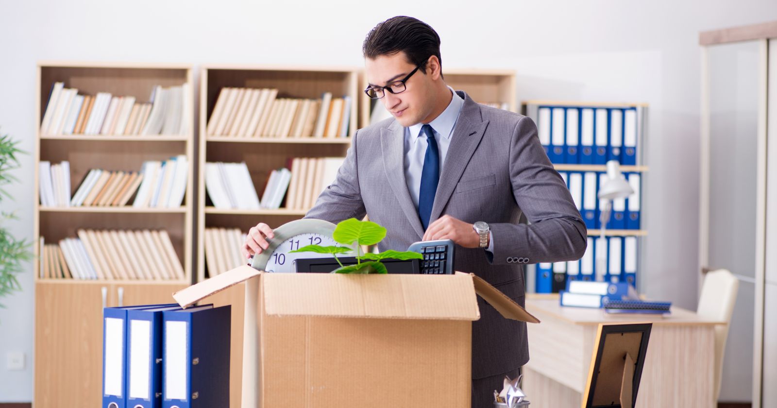 A man packing things at the office. A visual representation of office relocation.