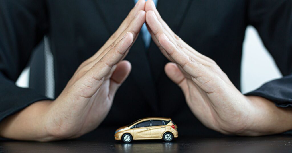 A man in a suit showcasing a small car. Relevant to the topic of "Cost of Full Coverage Car Insurance".