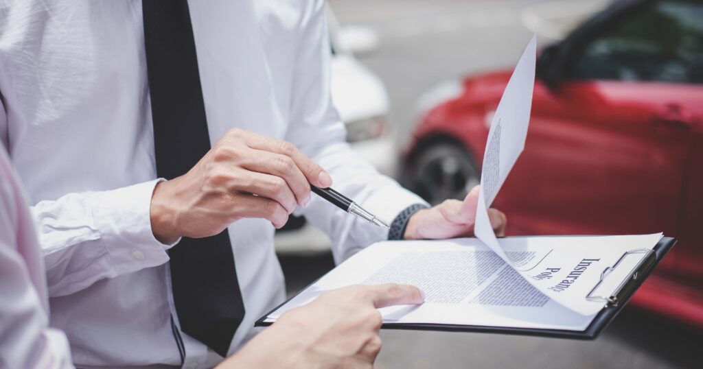 A professional man in formal attire holds a paper and pen, discussing 'Understanding Premiums and Deductibles'.