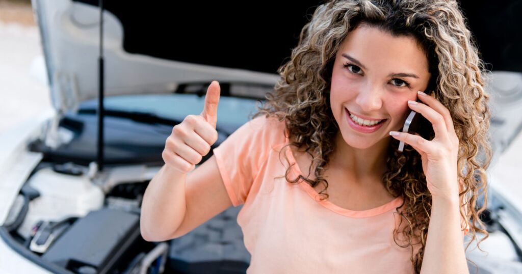 A woman sitting in front of a car, engaged in a phone conversation, emphasizing the importance of making informed decisions.