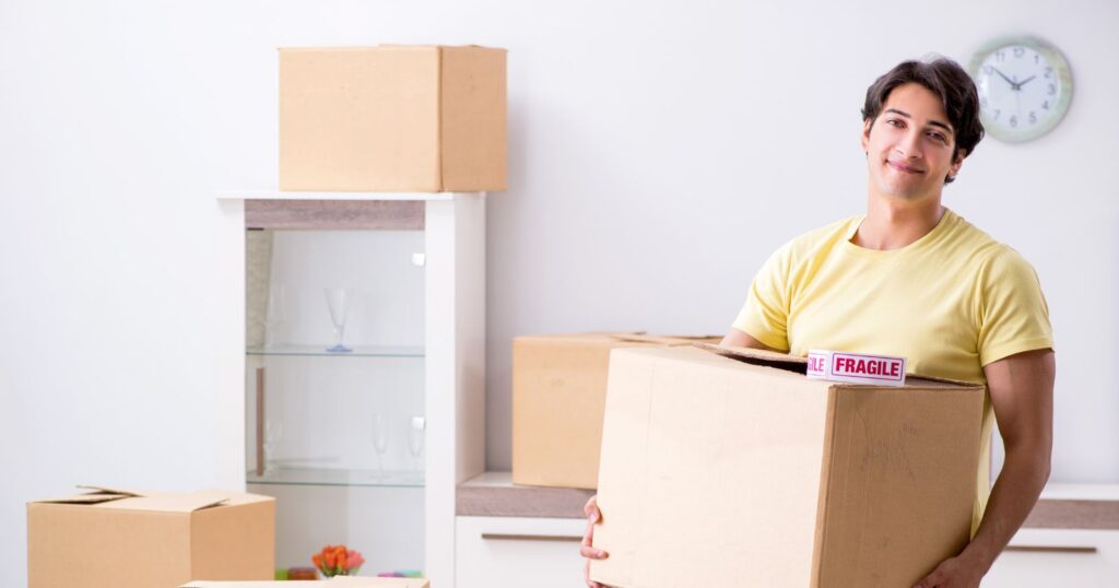 A man holding a box while moving, demonstrating appreciation through a thoughtful gesture.