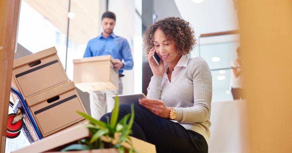 A woman on the office calling for a professional moving company.