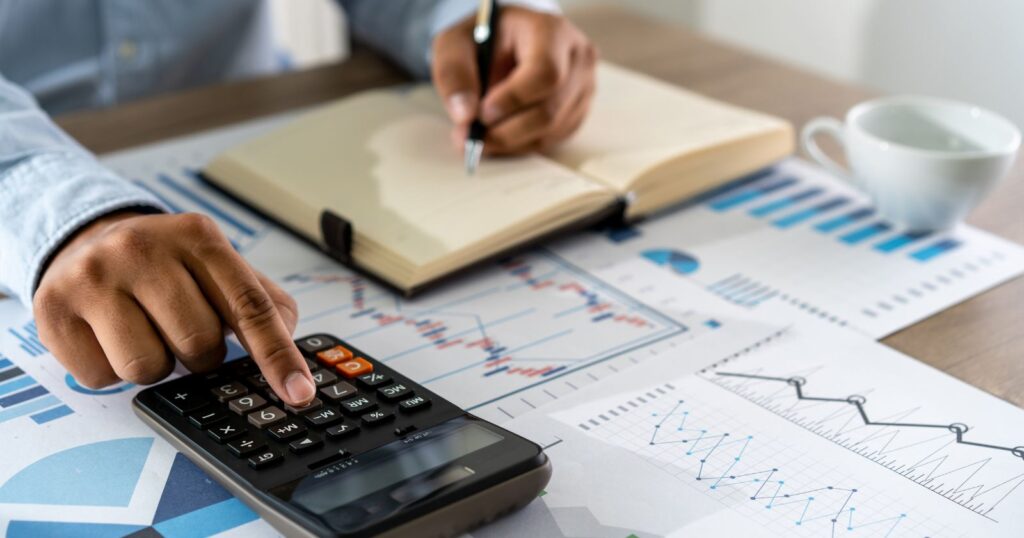 Image of a businessman using a calculator for financial data calculation. Steps to Effective Loan Calculation.