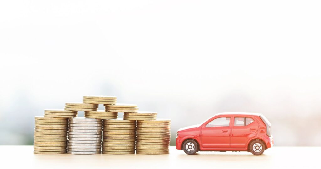 A small car perched on stacks of coins, symbolizing savings and discounts for navigating financial opportunities.