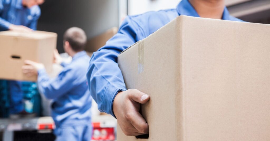 Professional movers handling furniture and boxes. Learn about tipping etiquette for movers.