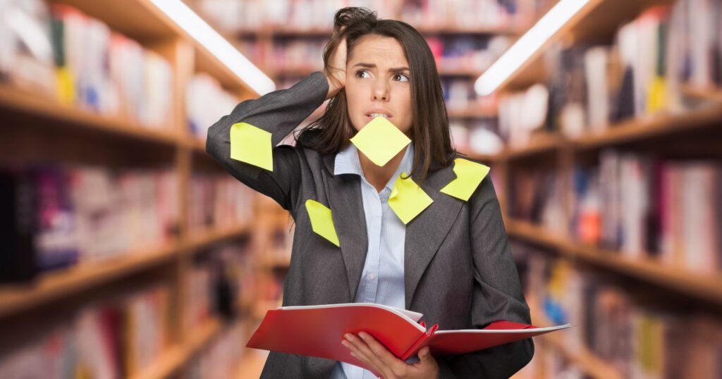 A professional woman in a suit holds a book and sticky notes, preparing for the GED Test.