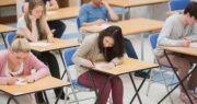 A diverse group of students sitting at desks in a classroom, focused on their studies. GED Test: Unlocking Opportunities for a Brighter Future.